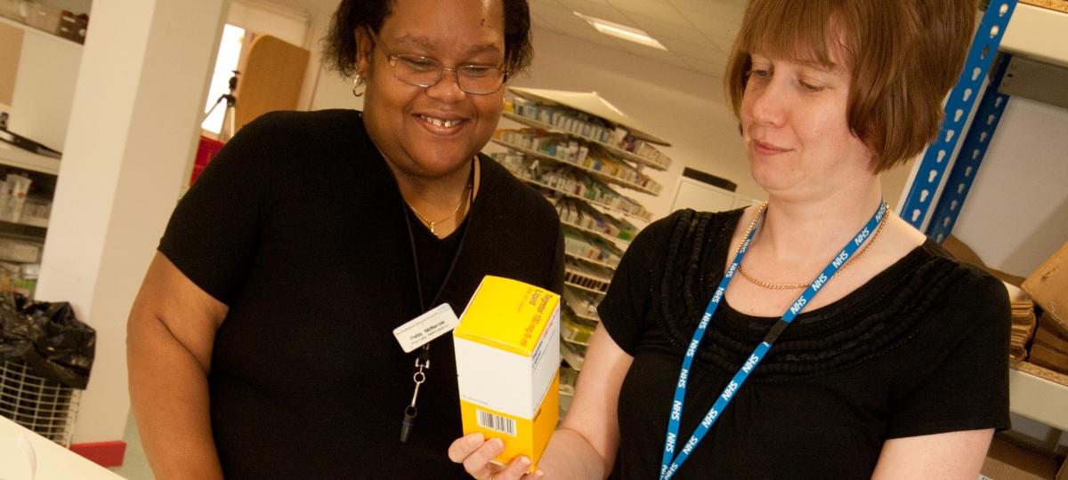 Two women in a pharmacy looking at medicine