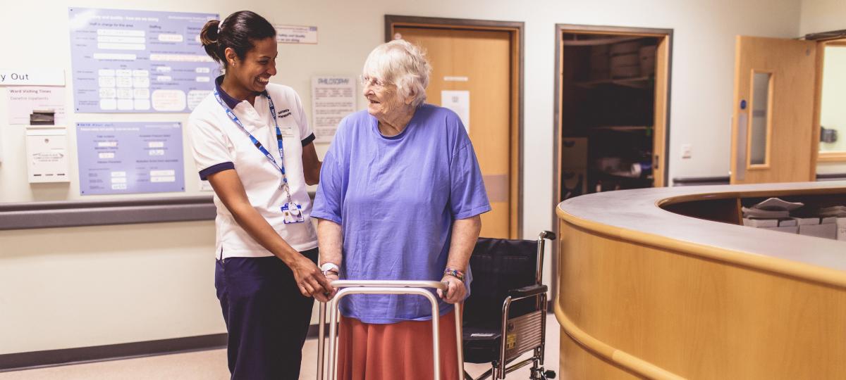 Therapist with elderly women using a walking frame