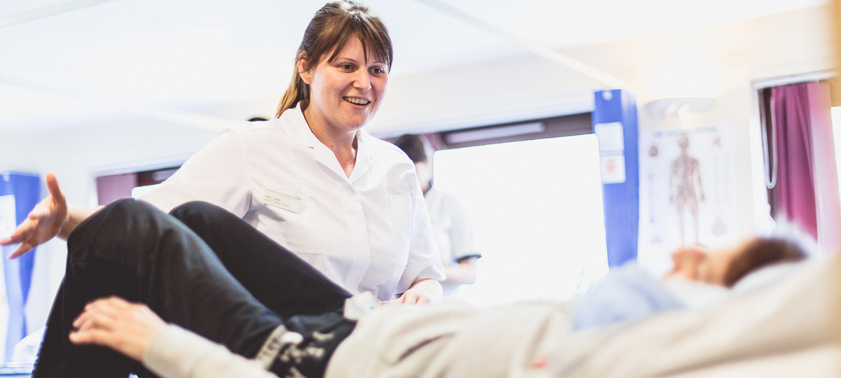 Physotherapist and service user on bed