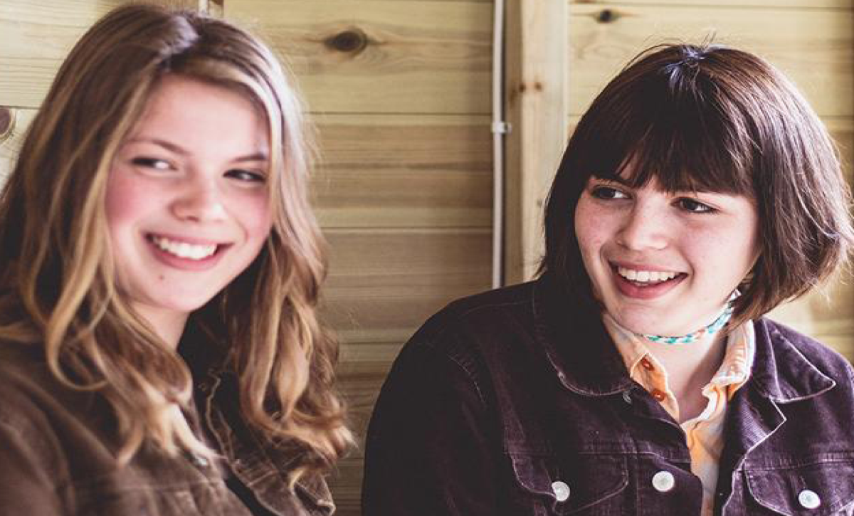 Two teenagers smiling at the camera