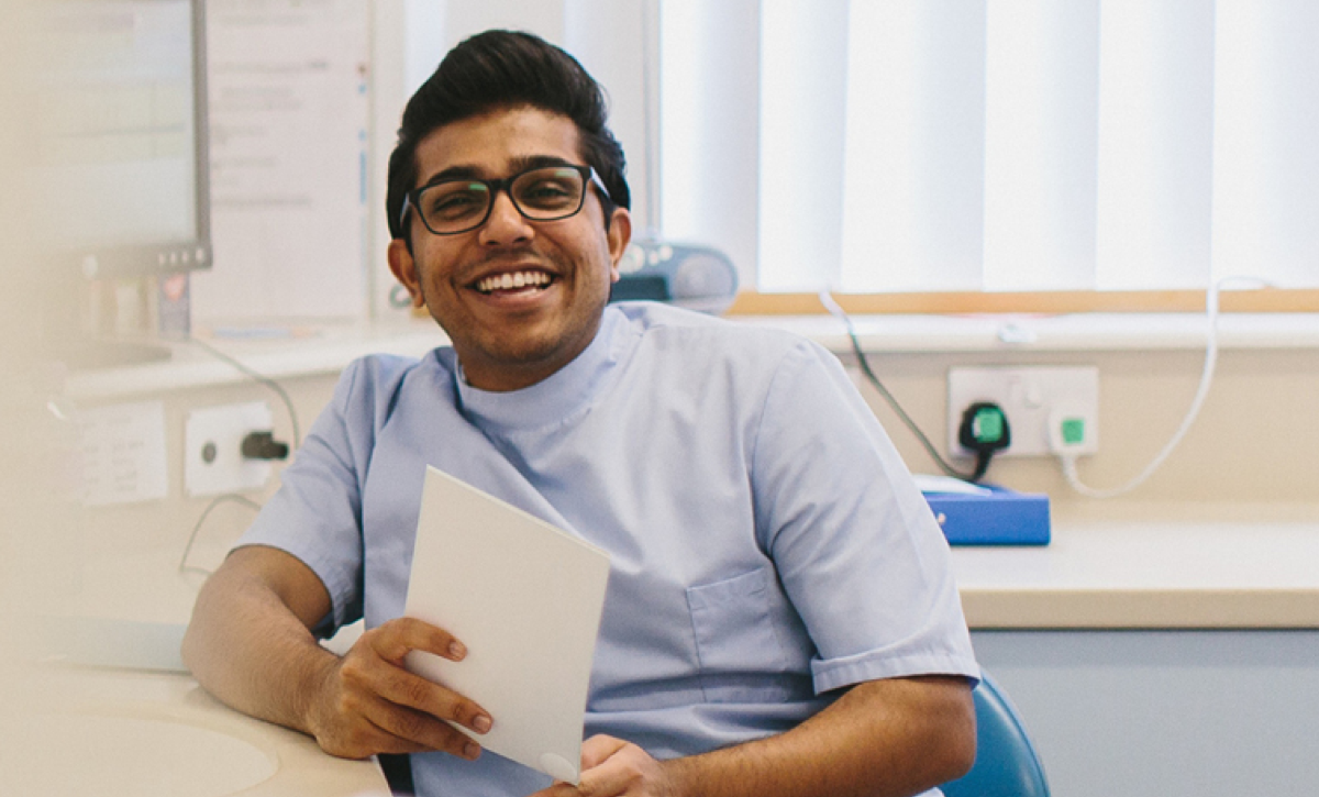 Male dentist in clinic holding paper