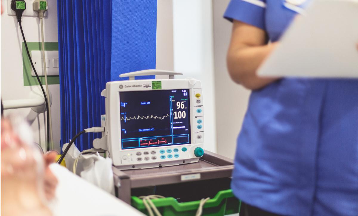 Nurse standing by a monitor screen on an inpatient ward