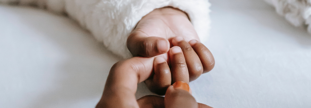 Baby holding mums hand