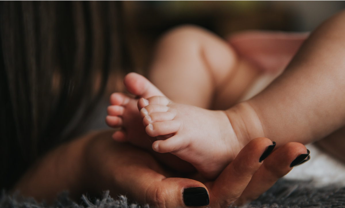 Woman holding baby's foot