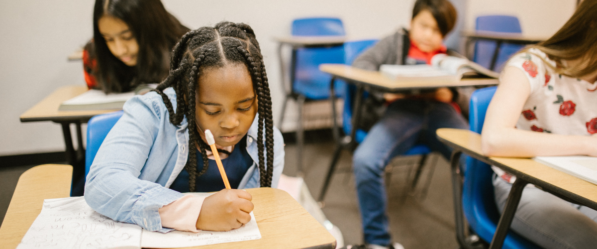 Child sat at desk in a classroom