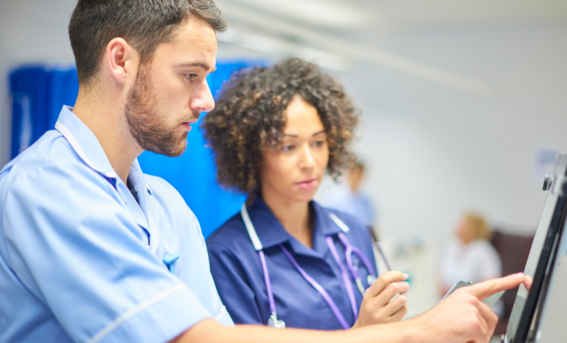 Image of a young male doctor and female nurse looking at patient details