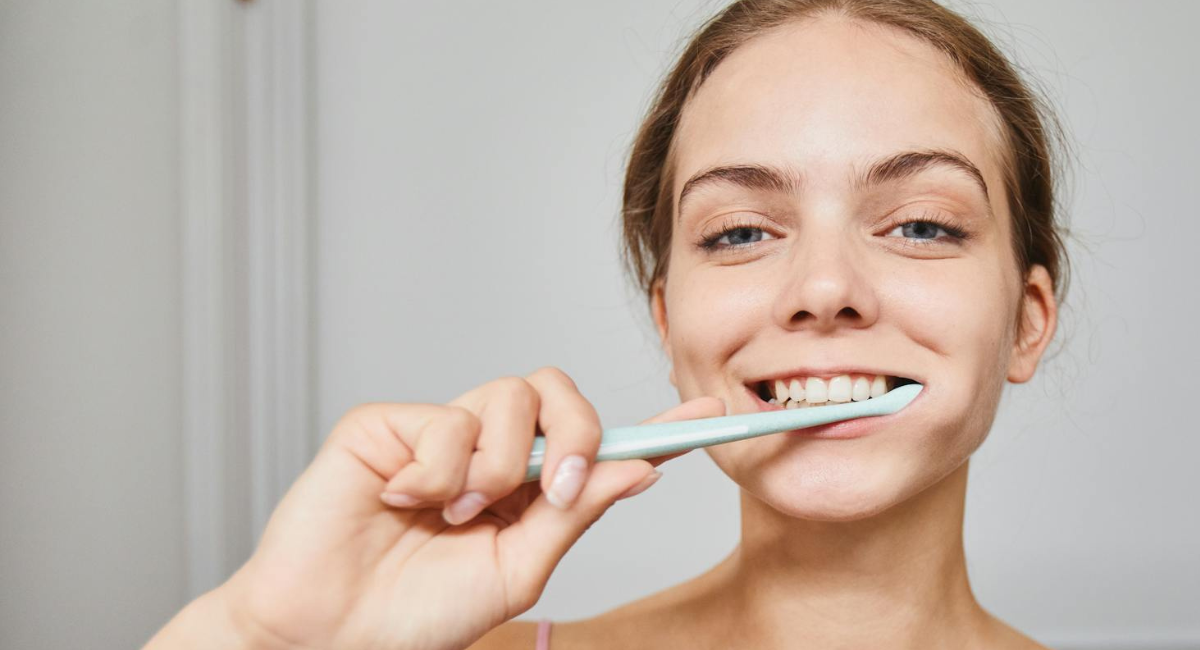 Girl smiling and brushing teeth