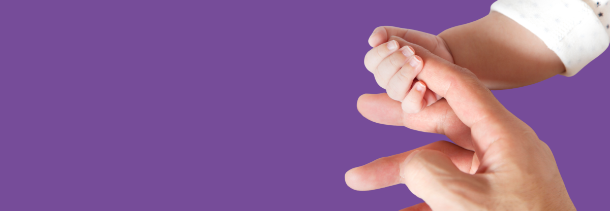 Hand holding newborn hand