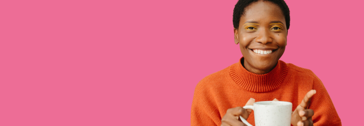 A cutout image of a woman smiling while holding a mug against a pink background