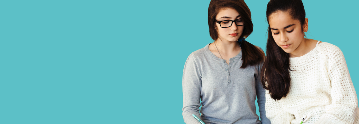 Two teenage girls studying together against a teal background