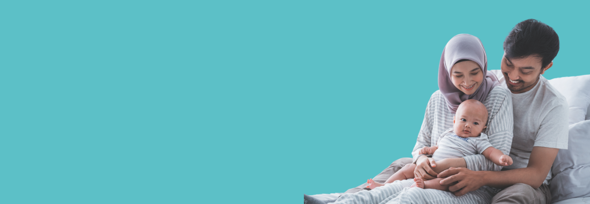 Dad and mum with their newborn baby against a teal background