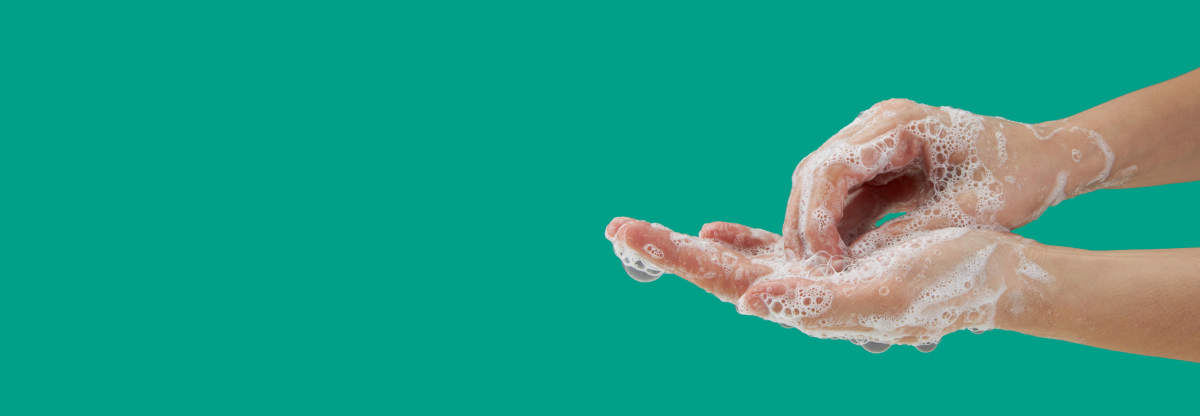 A cutout image of hands being washed with soap against a green background