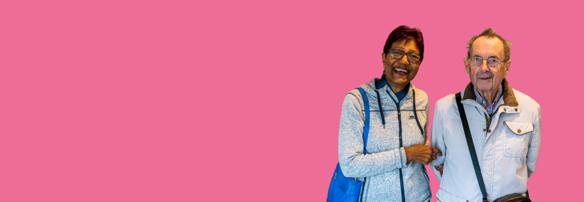A cutout image of an older man and woman smiling together against a pink background