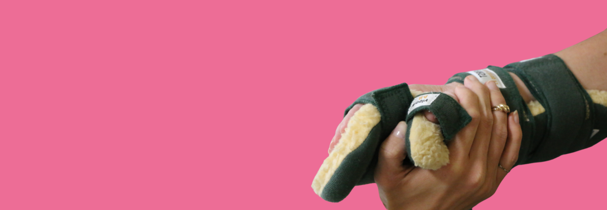 A cutout image of a hand in a splint against a pink background