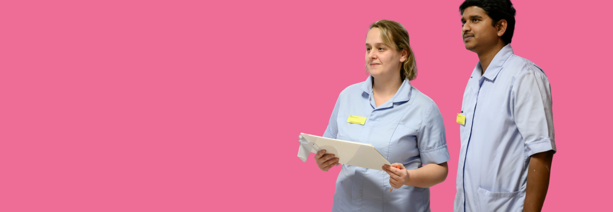 A male and a female healthcare assistant looking off to the left against a pink background