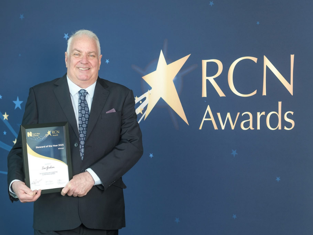 Picture of Ian Graham smiling and holding his award