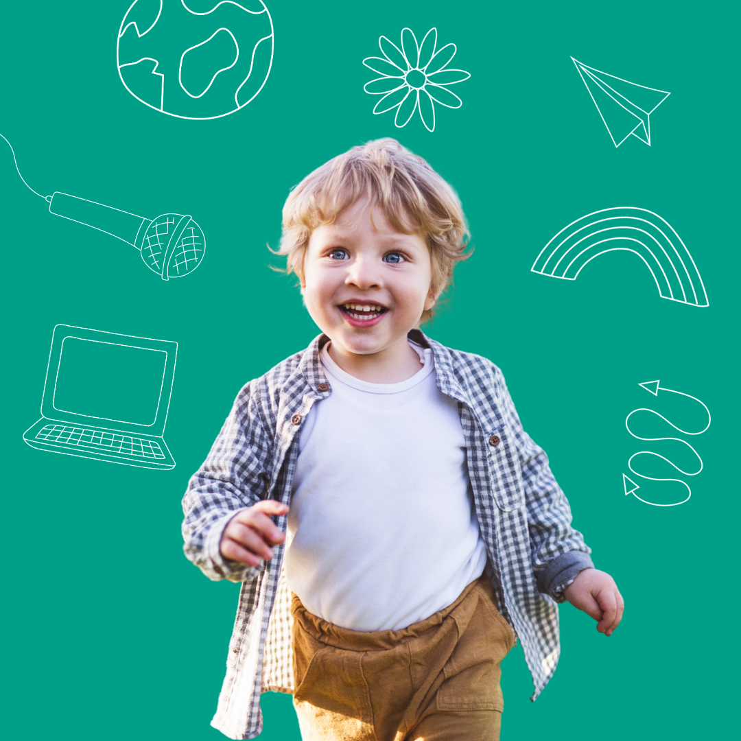 A smiling toddler running against a green background with doodles